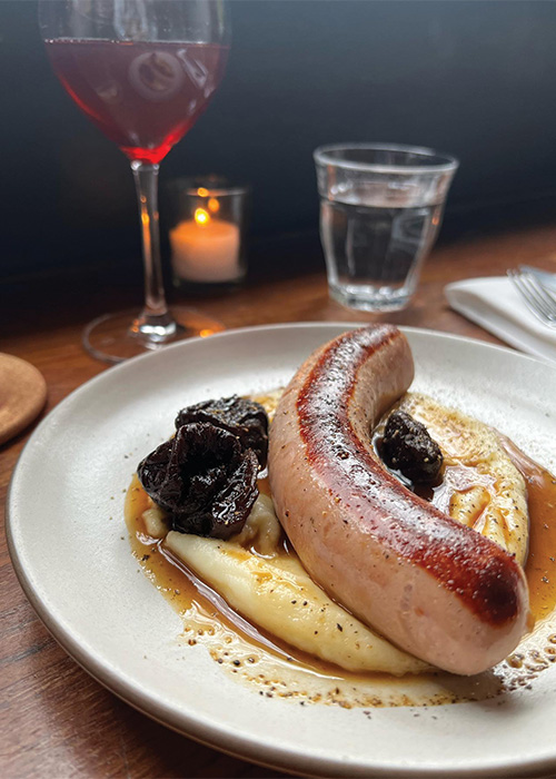 Une grosse saucisse imposante est l’une des meilleures petites assiettes de bar à vin. Découvrez le reste du classement ici.