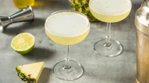 Cocktail secoué rafraîchissant au citron vert et à l'ananas dans un verre coupé