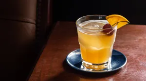 Amaretto Sour sur une table en bois avec un dessous de verre argenté